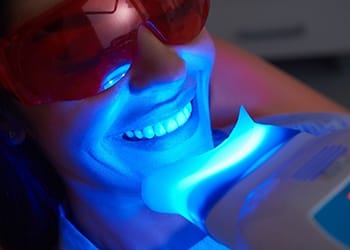 Woman smiling during teeth whitening treatment