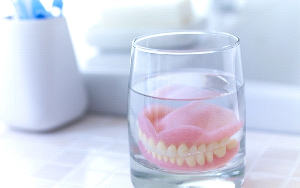 Dentures in Falls Church soaking in glass