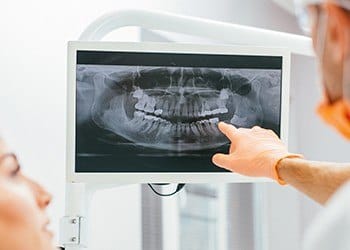 Dentist pointing to dental x-ray