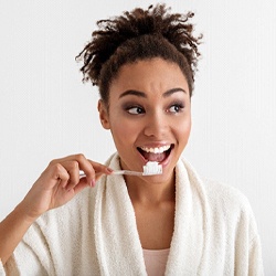 Woman smiling while she is about to brush her teeth