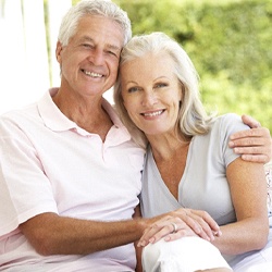Older couple smiling together while sitting outside