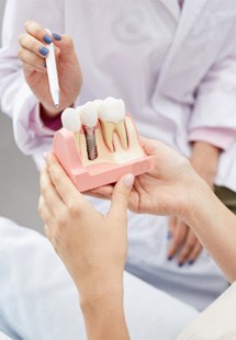 patient looking at dental implant model