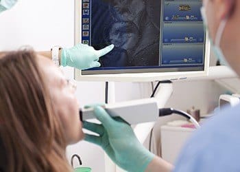 Dentist and patient looking at intraoral photos