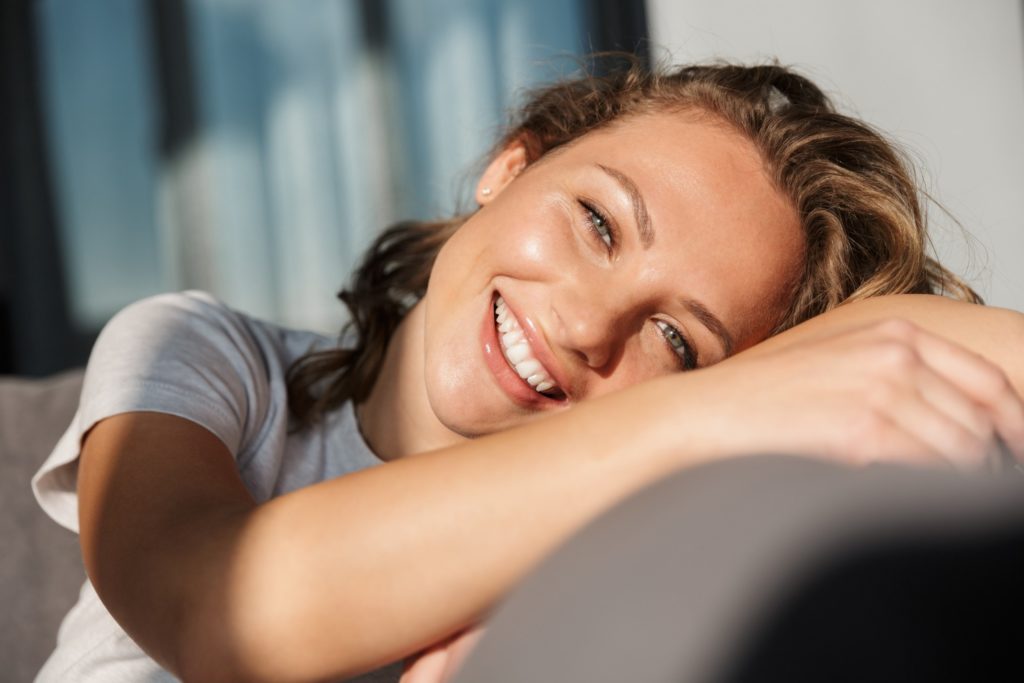 Closeup of woman smiling while relaxing on couch